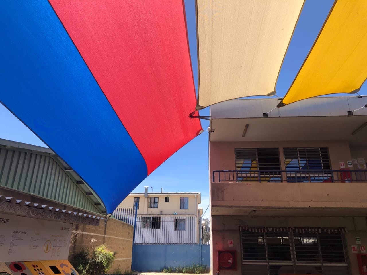 Velarias rojas y azules instaladas en un espacio educativo