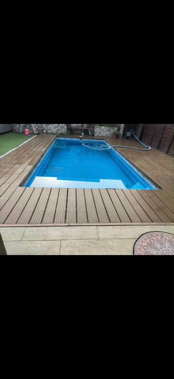 Piscina de fibra terminada y rodeada por un deck