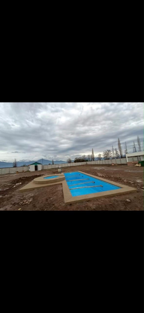 Piscina de fibra con spa integrado en un entorno abierto