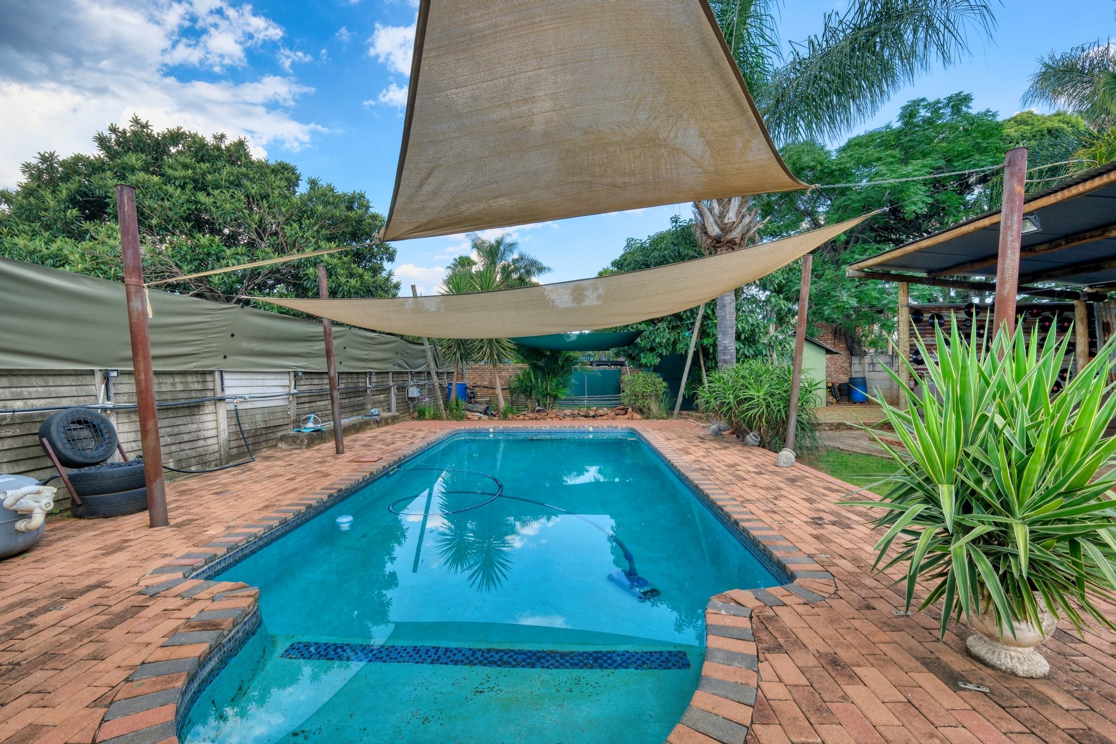 Piscina exterior protegida por velarias y toldos de sombra